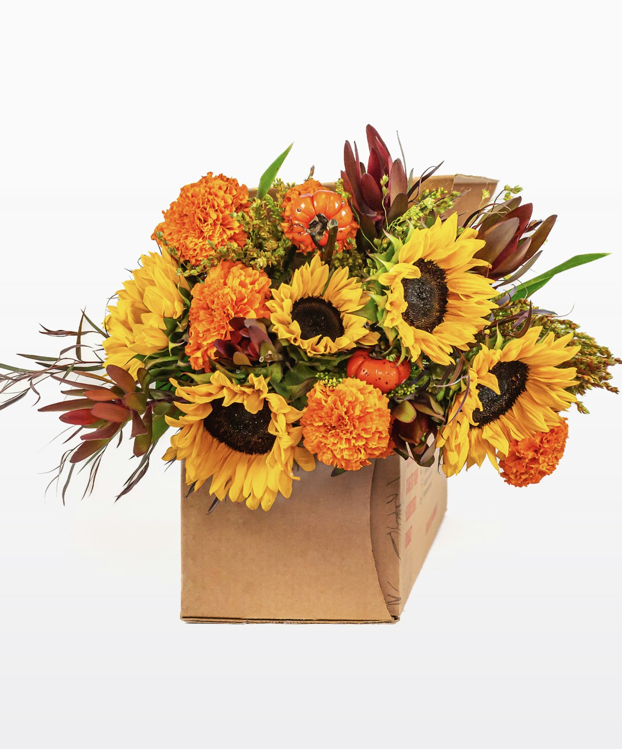 Vibrant bouquet of sunflowers, marigolds, and autumn accents in a rustic box.