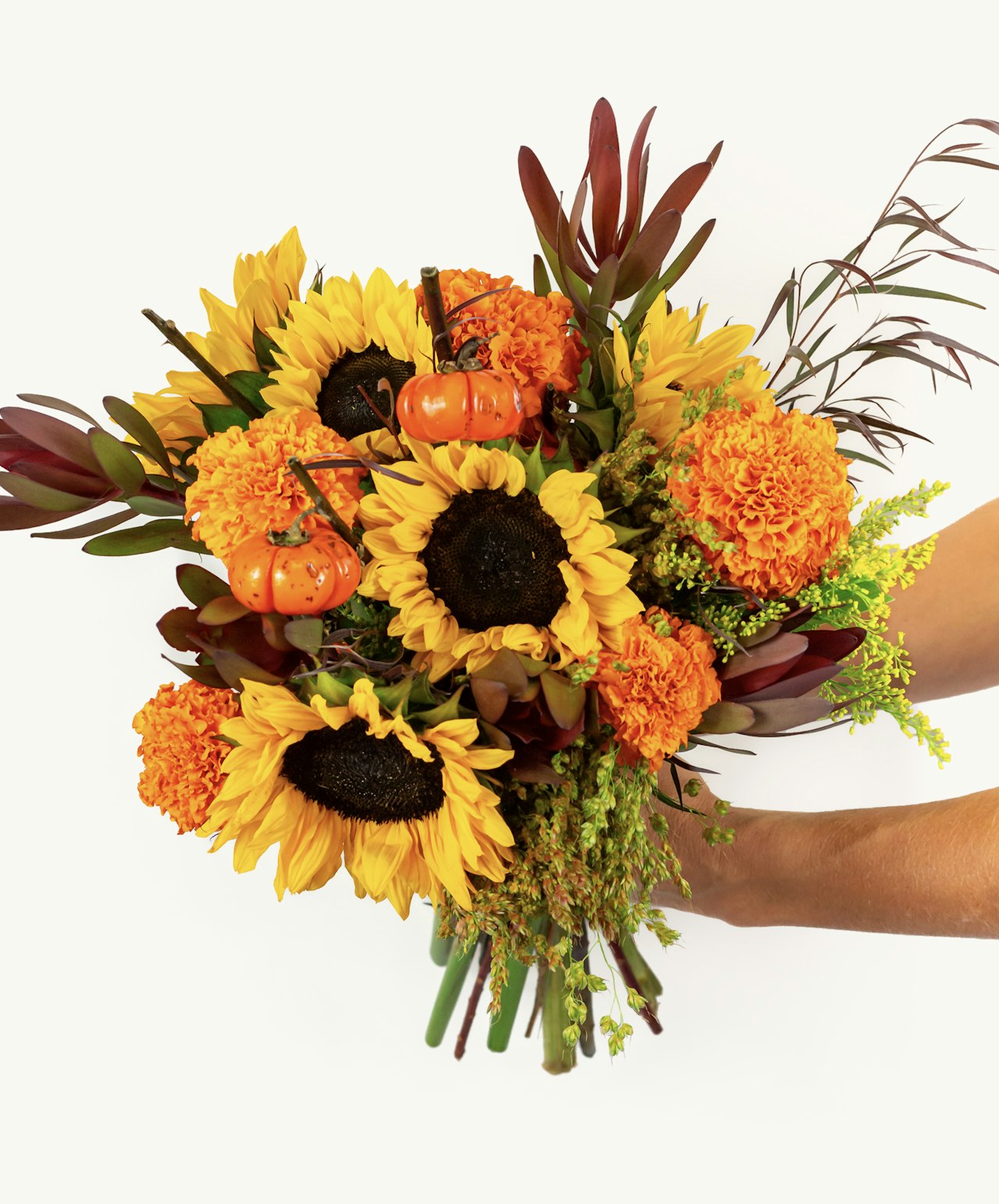 Vibrant autumn bouquet featuring sunflowers, marigolds, and seasonal pumpkins.