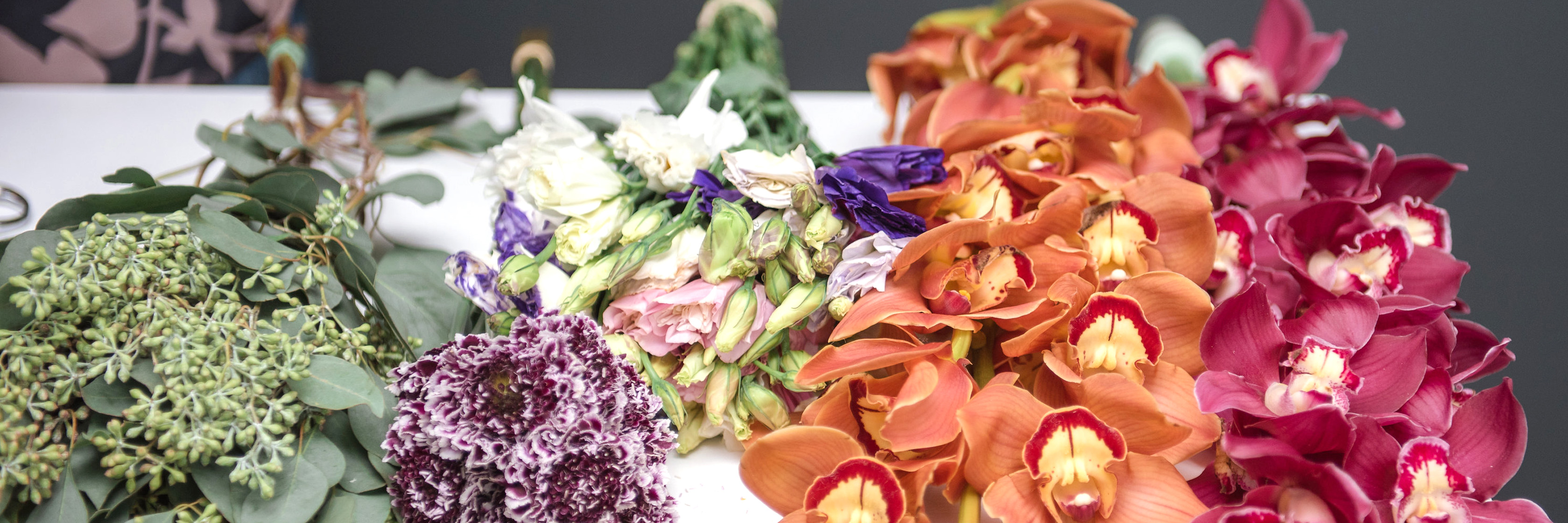 Vibrant assortment of fresh flowers, including orchids and colorful blooms, ideal for arrangements.