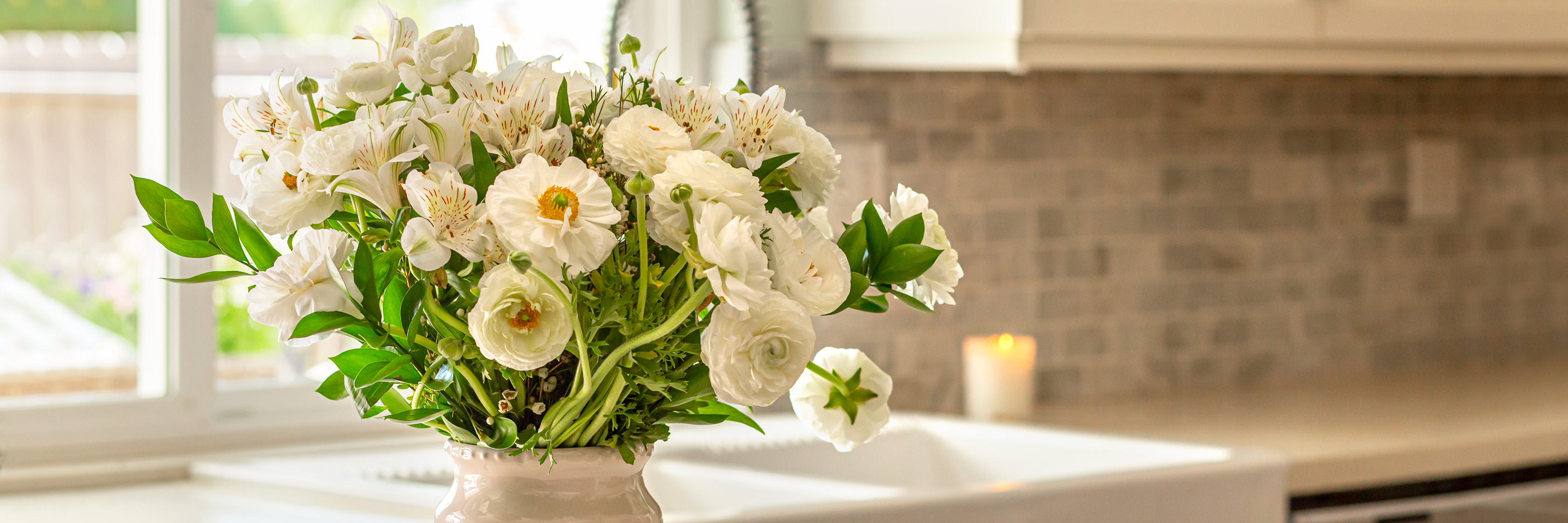 Elegant white flower arrangement in a vase, brightening up a modern kitchen space.
