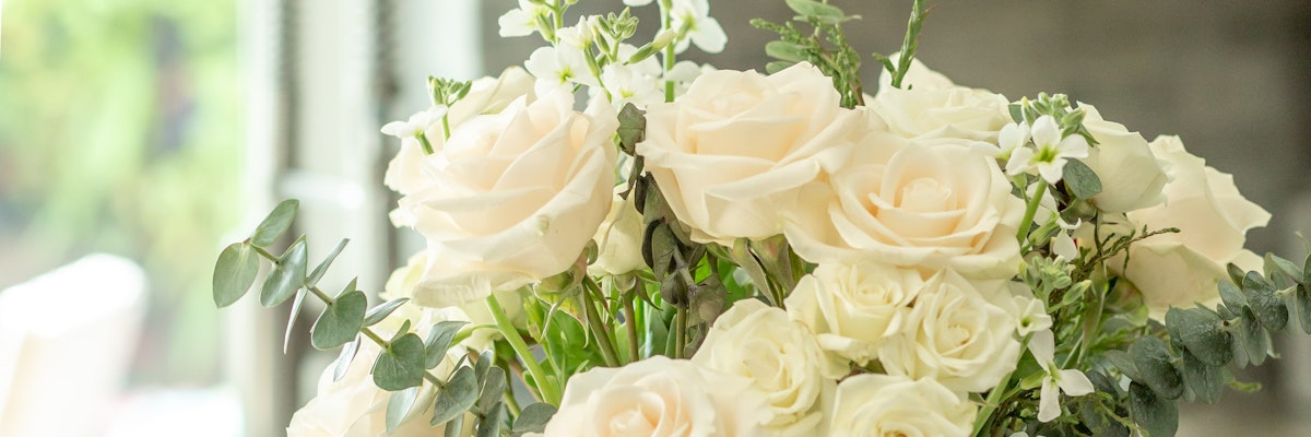 Elegant bouquet of white roses with delicate greenery, perfect for weddings or anniversaries.