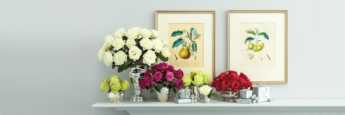 Elegant floral display featuring white, pink, and red roses on a mantel with vintage artwork.