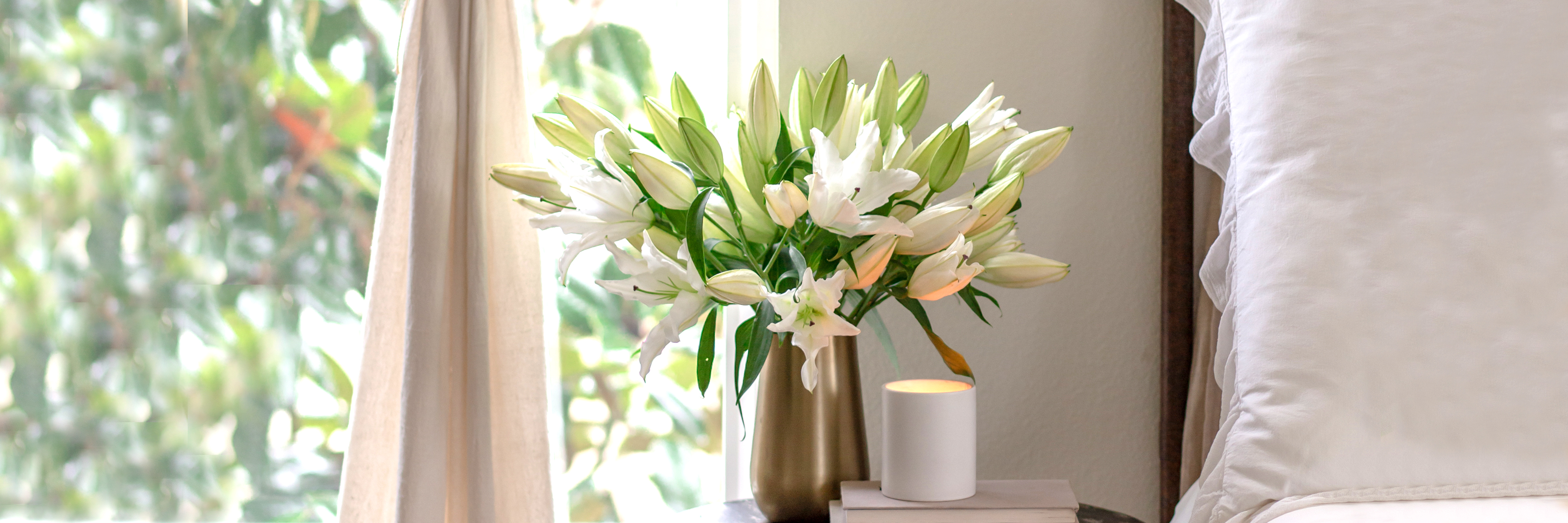 Elegant white lilies in a chic vase, enhancing a serene bedroom ambiance.