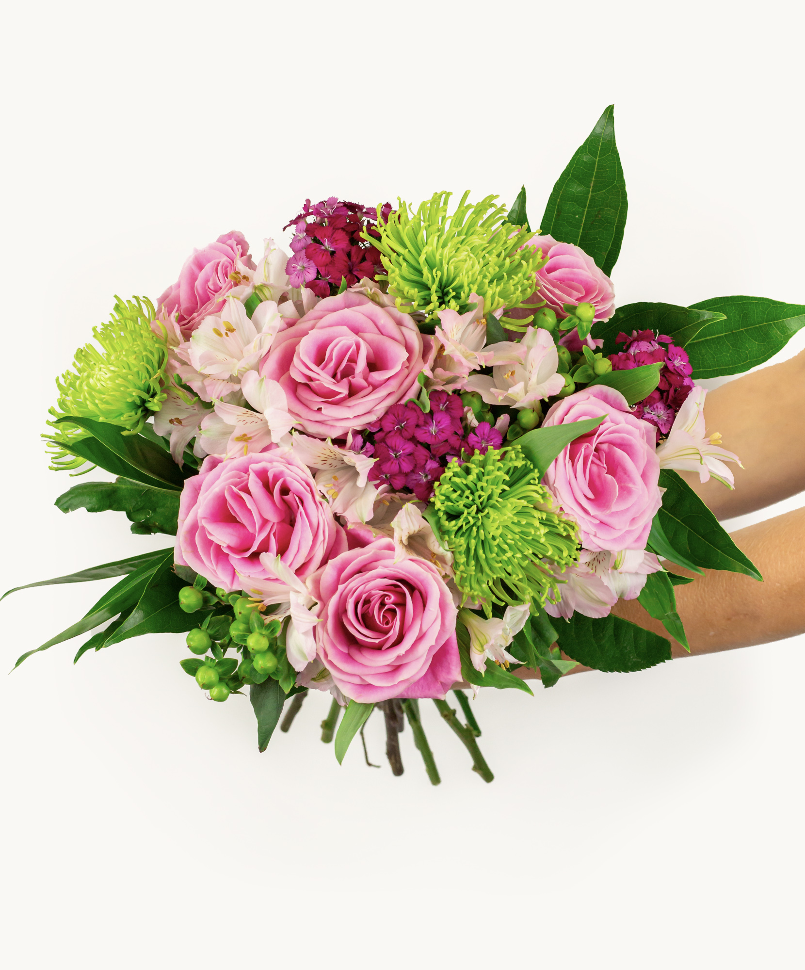 Delicate bouquet featuring pink roses, green pom-poms, and lush greenery, ideal for celebrations.