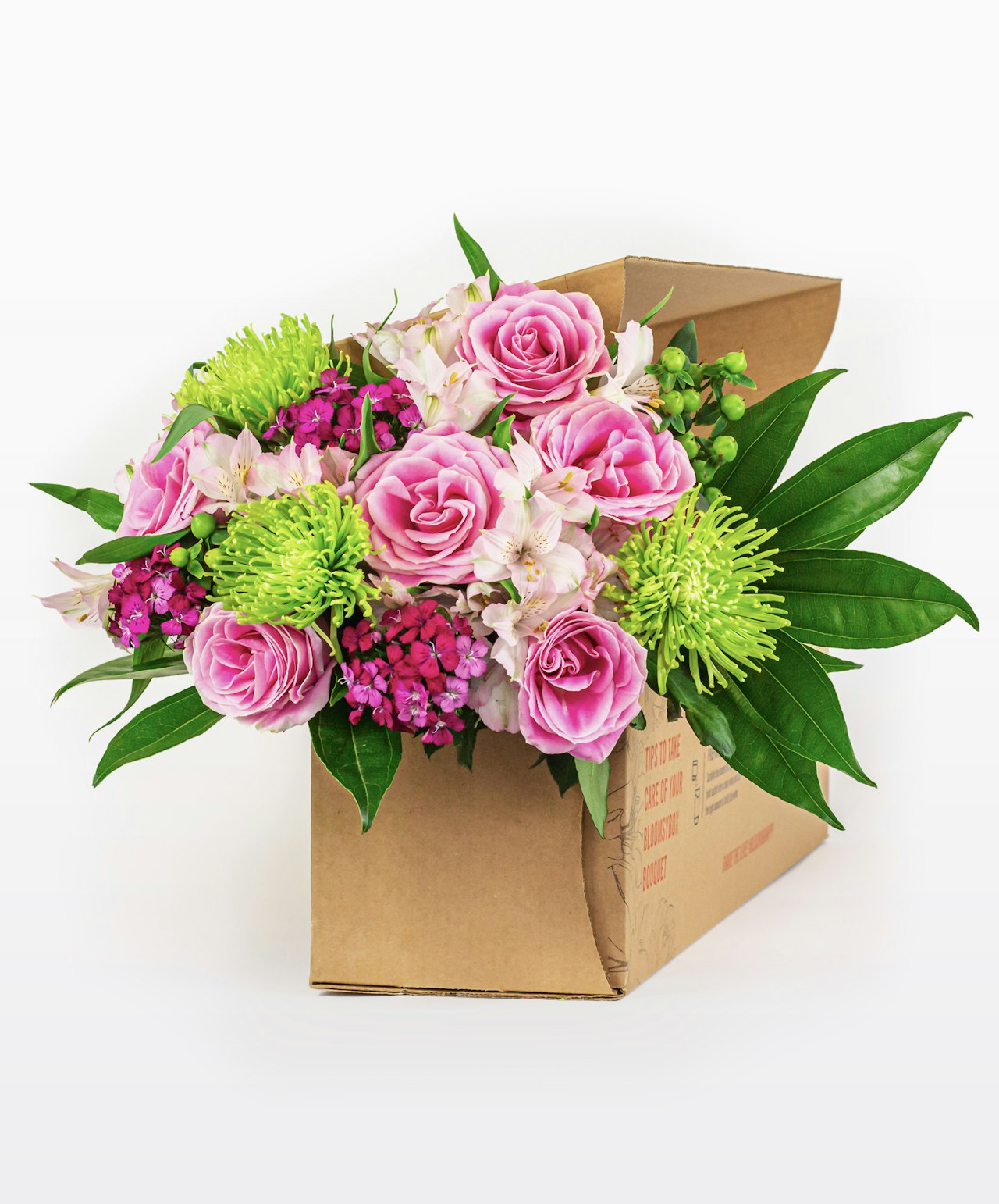 Vibrant bouquet featuring pink roses, green chrysanthemums, and lush greenery in a box.