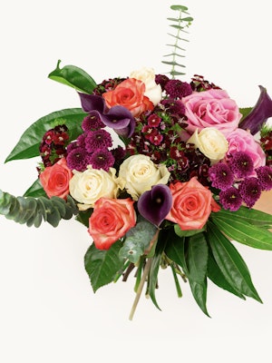 Vibrant floral bouquet featuring pink roses, purple calla lilies, and lush greenery.