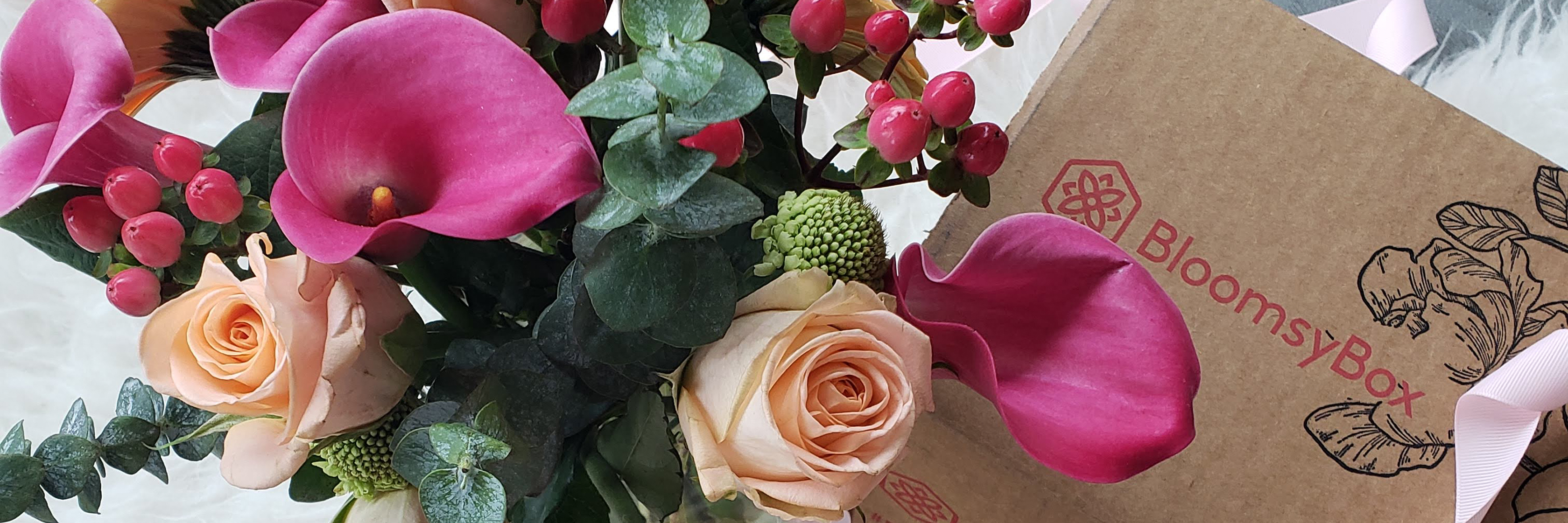Vibrant floral arrangement featuring pink calla lilies and rose blooms in a BloomsyBox package.