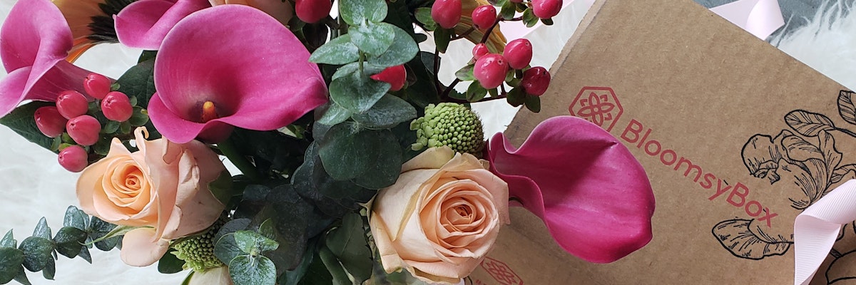Vibrant floral arrangement featuring pink calla lilies and rose blooms in a BloomsyBox package.