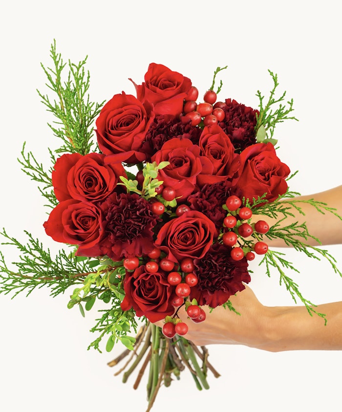 Vibrant red roses and deep maroon carnations in a lush, celebratory bouquet.