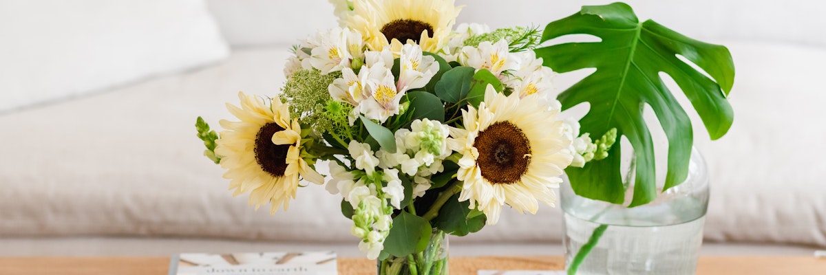 Vibrant floral arrangement featuring sunflowers and white blooms, elegantly displayed.