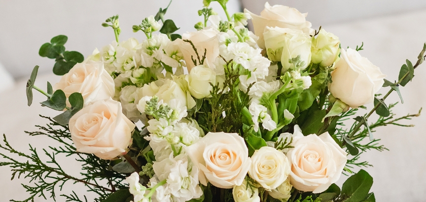 Elegant bouquet featuring soft pink roses, white stock flowers, and lush greenery.