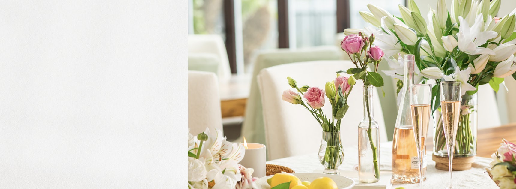 Elegant floral arrangements with pink roses and white lilies on a bright dining table.