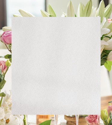 Elegant white card placed among a beautiful floral arrangement, ideal for personalization.