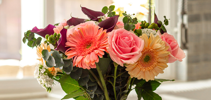 Vibrant bouquet featuring pink roses, gerbera daisies, and lush greenery, perfect for gifting.
