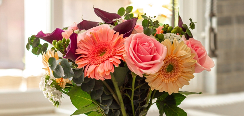 Vibrant bouquet featuring pink roses, gerbera daisies, and lush greenery, perfect for gifting.