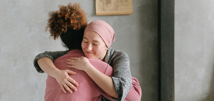 Two women embrace warmly in a cozy indoor setting, radiating love and support.