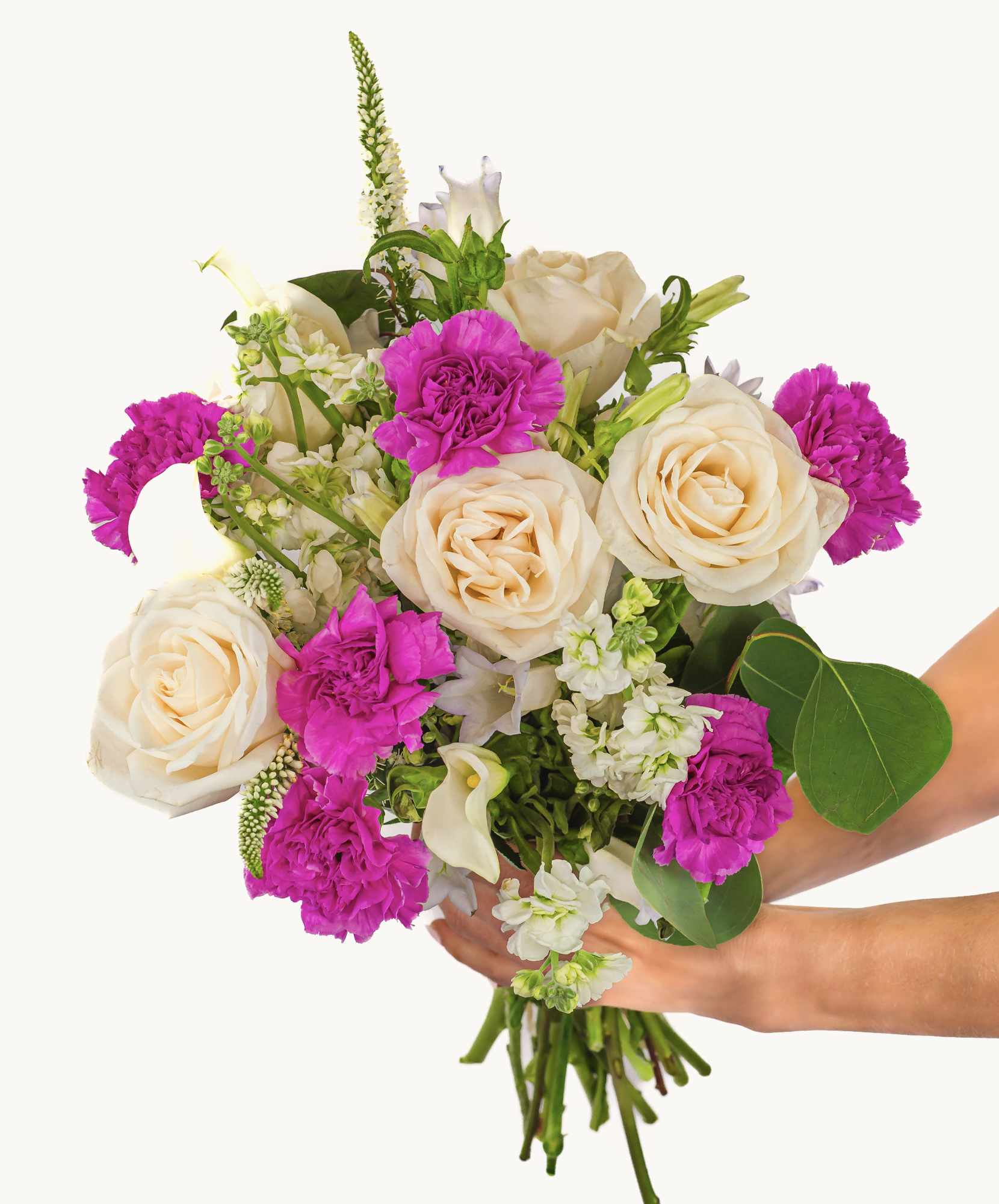 A vibrant bouquet featuring white roses, purple carnations, and lush greenery, elegantly held.