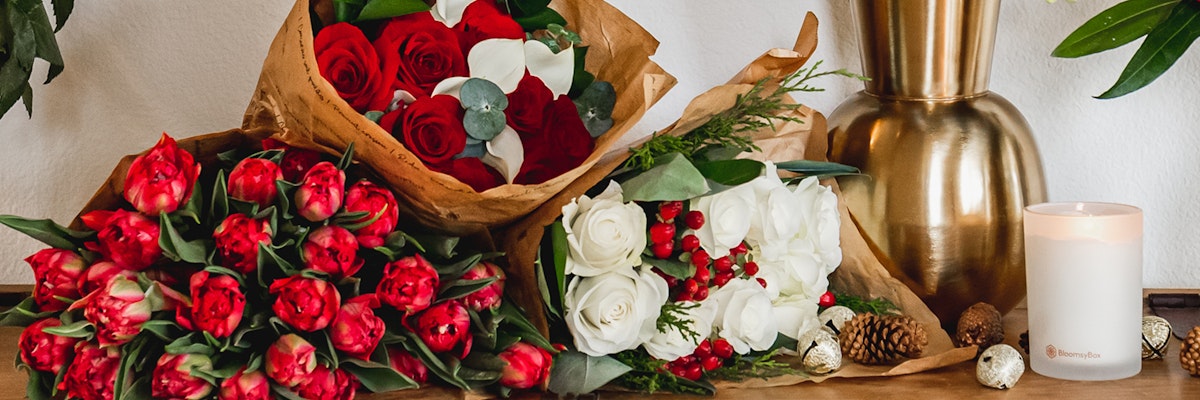 Vibrant floral arrangement featuring red roses, tulips, and white blooms elegantly displayed.