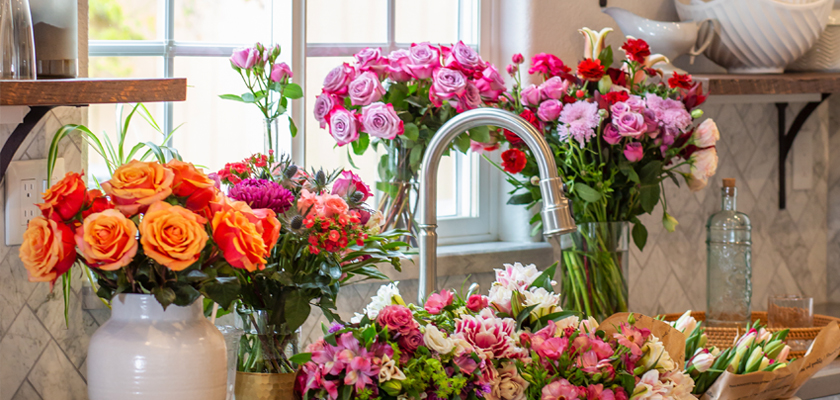 Vibrant floral arrangement featuring roses and mixed blooms in a bright kitchen setting.
