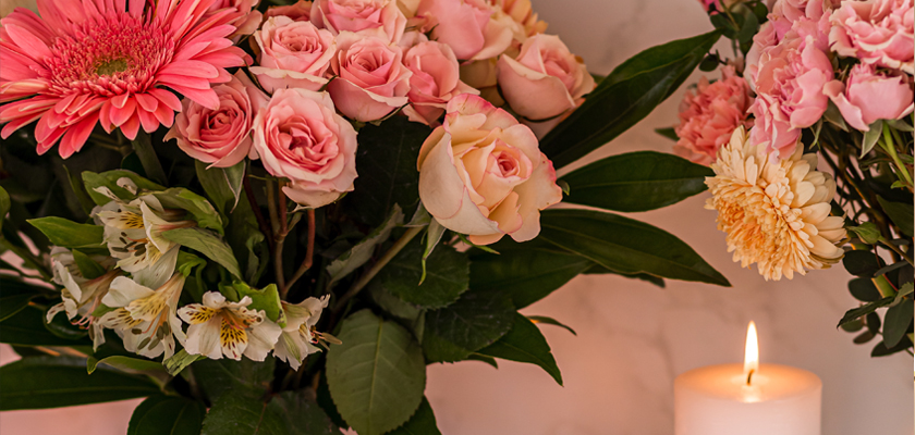 A beautiful floral arrangement featuring pink roses, gerbera daisies, and delicate greenery.
