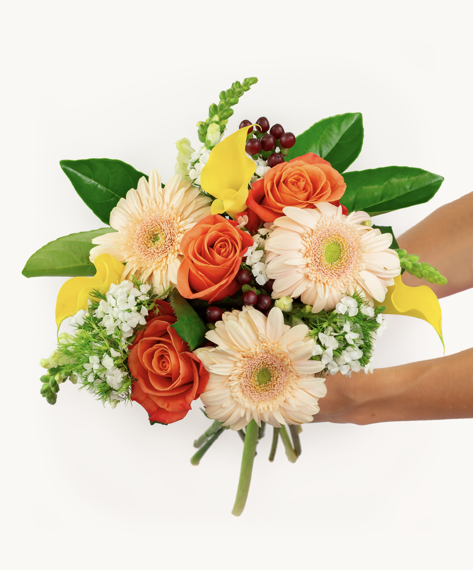Vibrant hand-held bouquet featuring peach roses, gerbera daisies, and greenery.