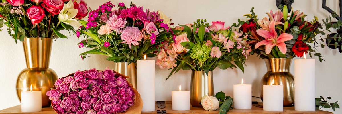 Elegant floral display featuring vibrant pink flowers and soft candles, perfect for home decor.