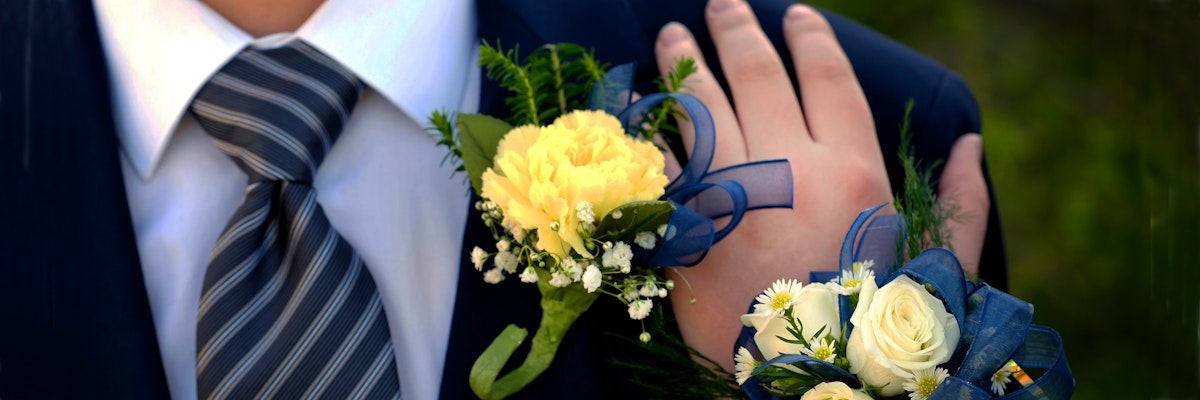 Elegant boutonniere and corsage featuring yellow roses and greenery, perfect for prom.