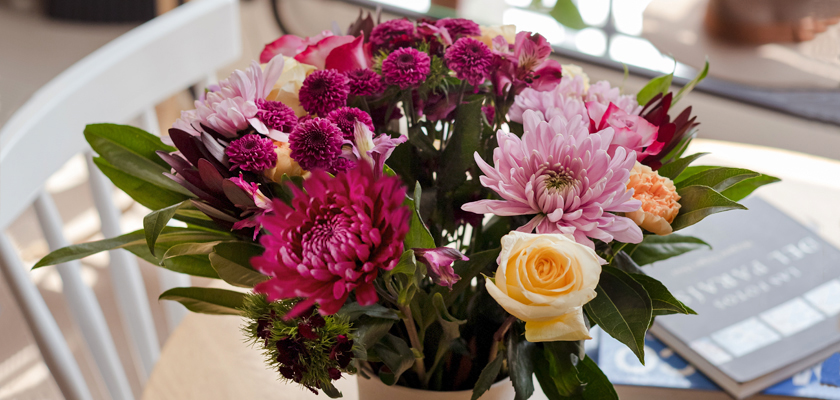 Vibrant floral arrangement featuring pink and purple blooms with lush green foliage.