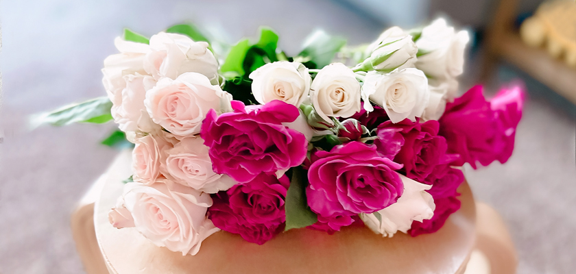 Elegant arrangement of pink and white roses with lush greenery, perfect for celebrations.