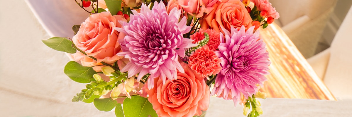 Vibrant floral arrangement featuring pink chrysanthemums and peach roses in a charming bouquet.