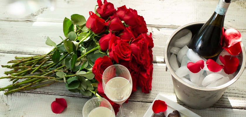 Elegant red roses with champagne and chocolates, perfect for a romantic celebration.
