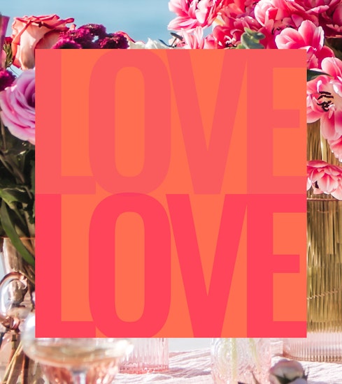 Vibrant table setting with colorful flowers and a bold "LOVE" graphic for celebrations.