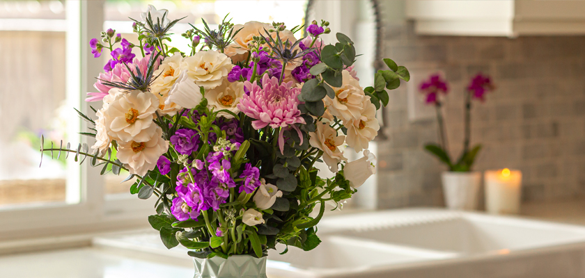 Vibrant floral arrangement featuring pink and purple blooms in a stylish kitchen setting.