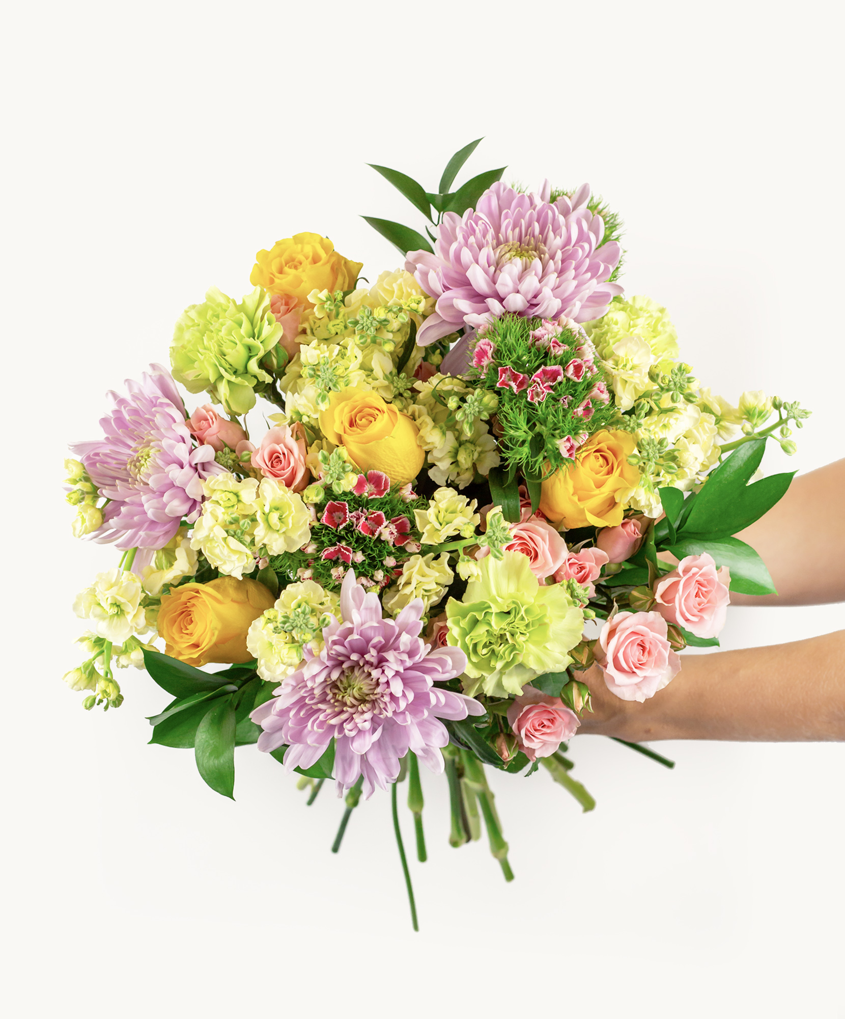 Vibrant floral bouquet featuring yellow roses, pink blooms, and lush green foliage.