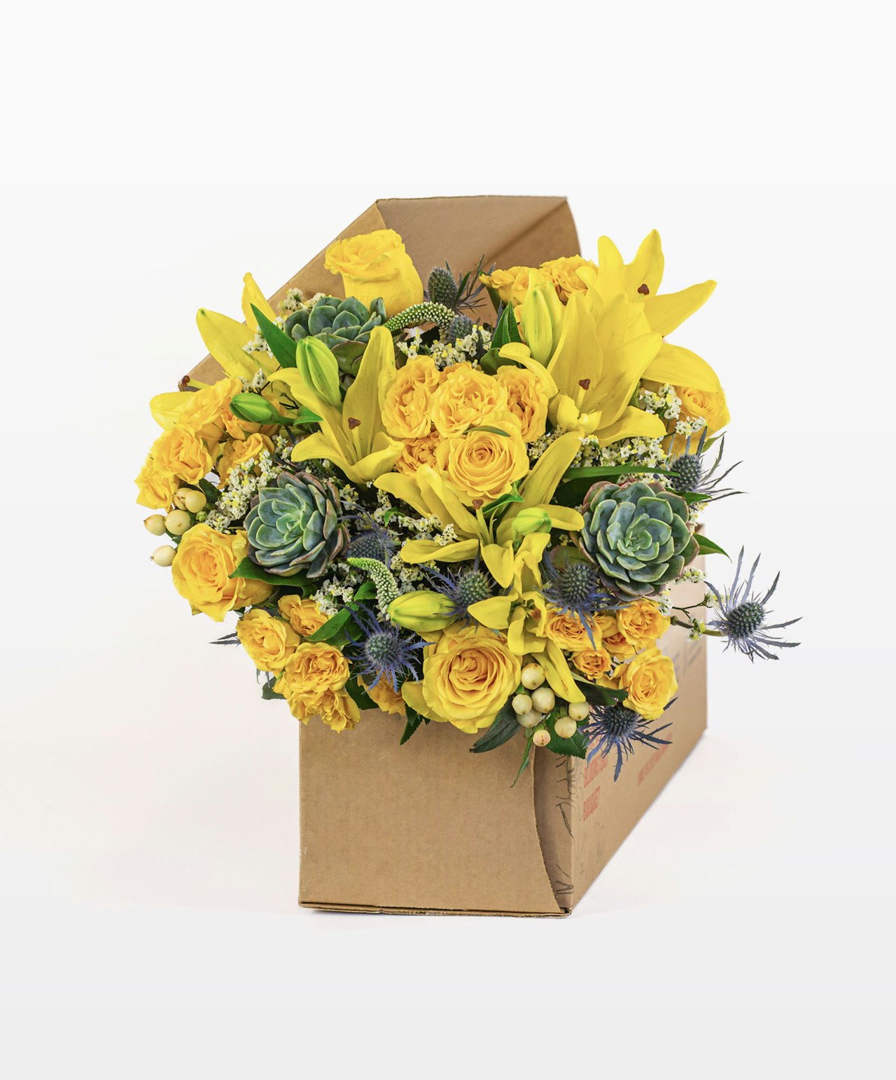 Bright and cheerful bouquet featuring yellow roses, lilies, and succulents in a cozy box.