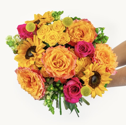 Vibrant bouquet featuring sunflowers, orange roses, and pink blooms, ideal for any celebration.
