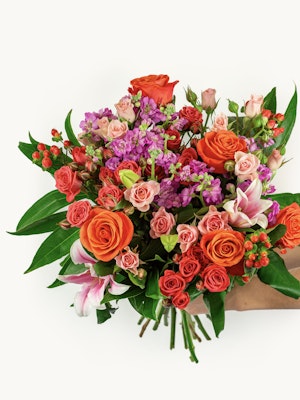 Vibrant floral bouquet featuring orange roses, pink blooms, and lush greenery, elegantly arranged.