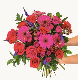 Vibrant bouquet featuring pink gerbera daisies and red roses, ideal for celebrations.