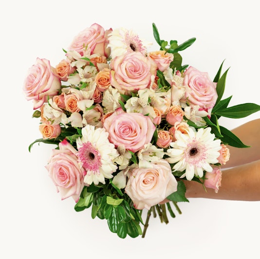 A vibrant bouquet featuring blush roses, gerberas, and lush greenery, perfect for any occasion.