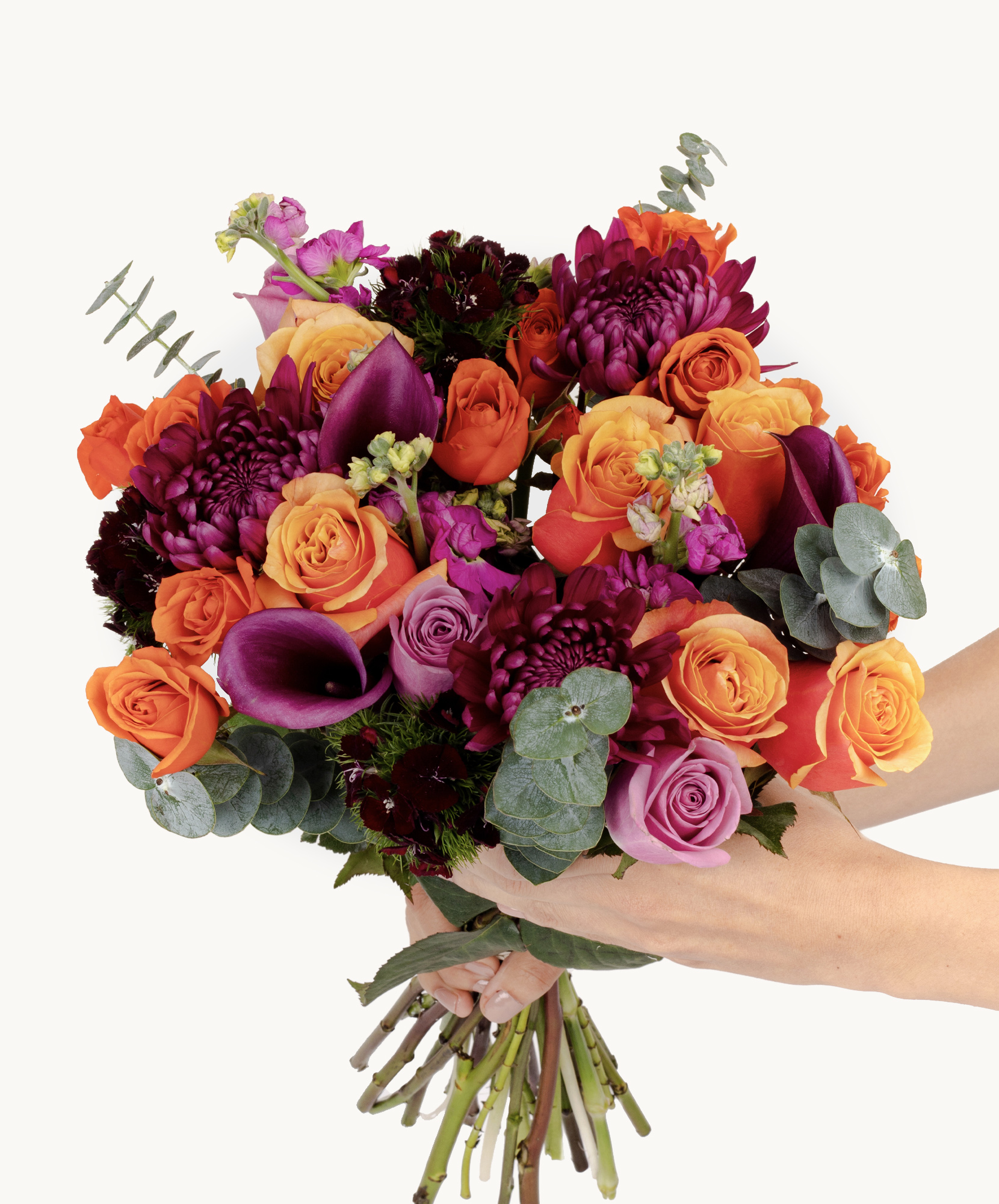 Vibrant floral bouquet featuring orange, purple, and pink roses amidst lush greenery.
