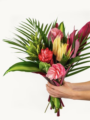 Vibrant tropical flower bouquet featuring pink, red, and green foliage, ideal for celebrations.