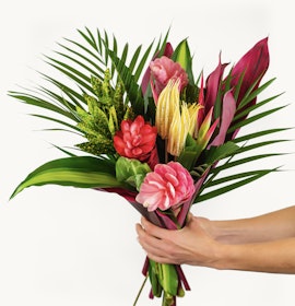 Vibrant tropical flower bouquet featuring pink, red, and green foliage, ideal for celebrations.