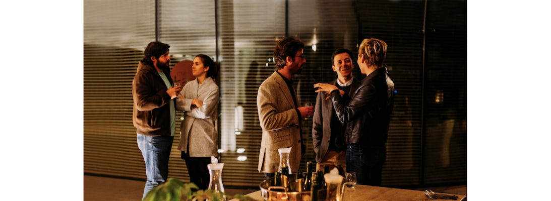 Elegant gathering of friends enjoying drinks and conversation at a stylish event.