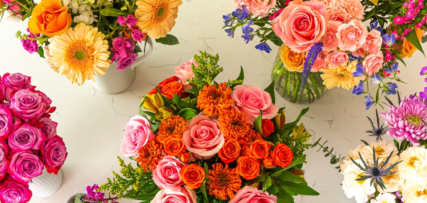 Vibrant floral arrangements featuring pink, orange, and yellow blooms in stylish vases.