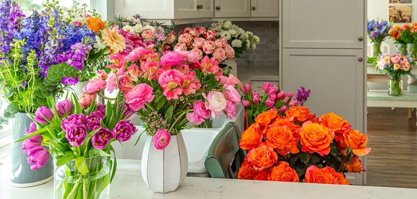 Vibrant floral arrangements featuring pink, orange, and purple blooms in elegant vases.
