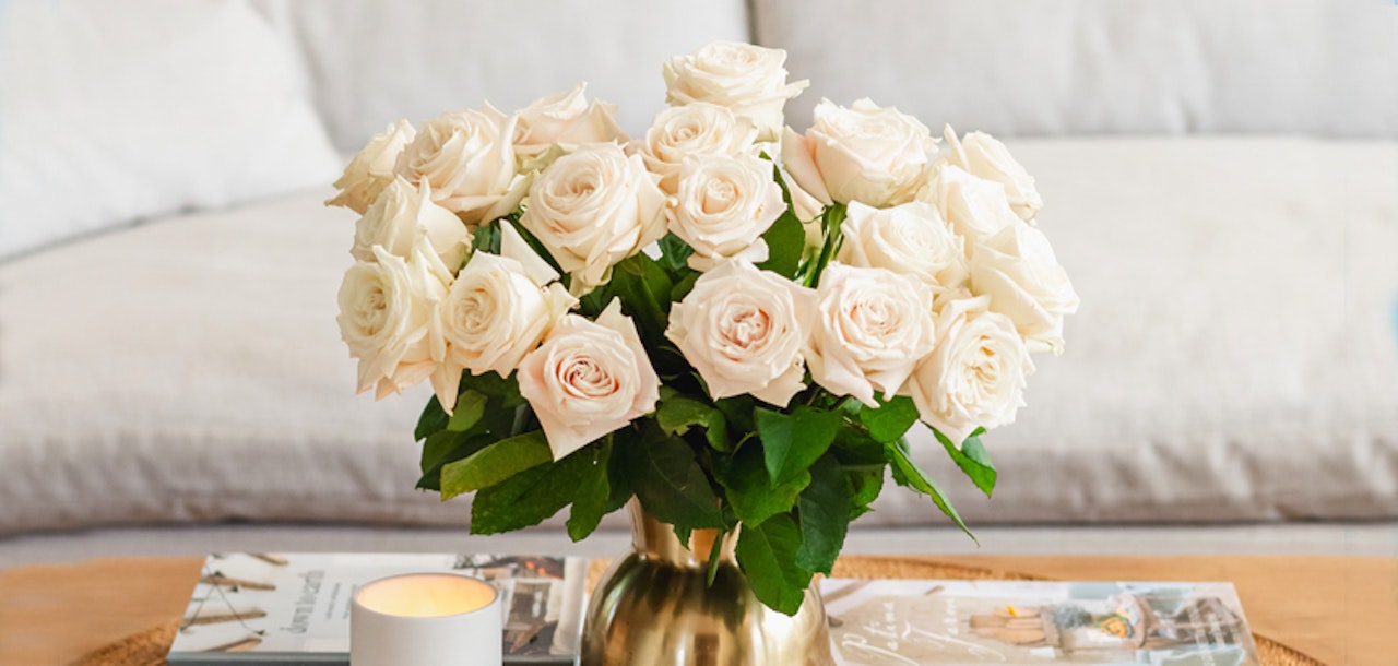 Elegant white roses in a stylish gold vase, adding sophistication to any living space.