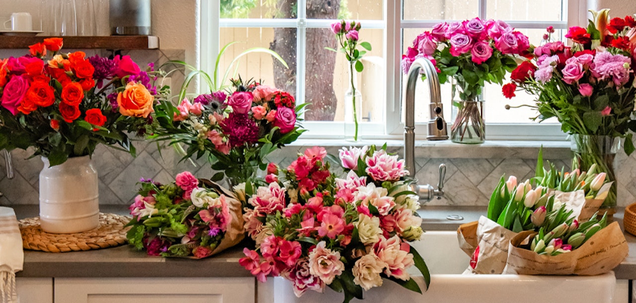 Vibrant floral arrangements of roses and lilies brightening a cozy kitchen space.