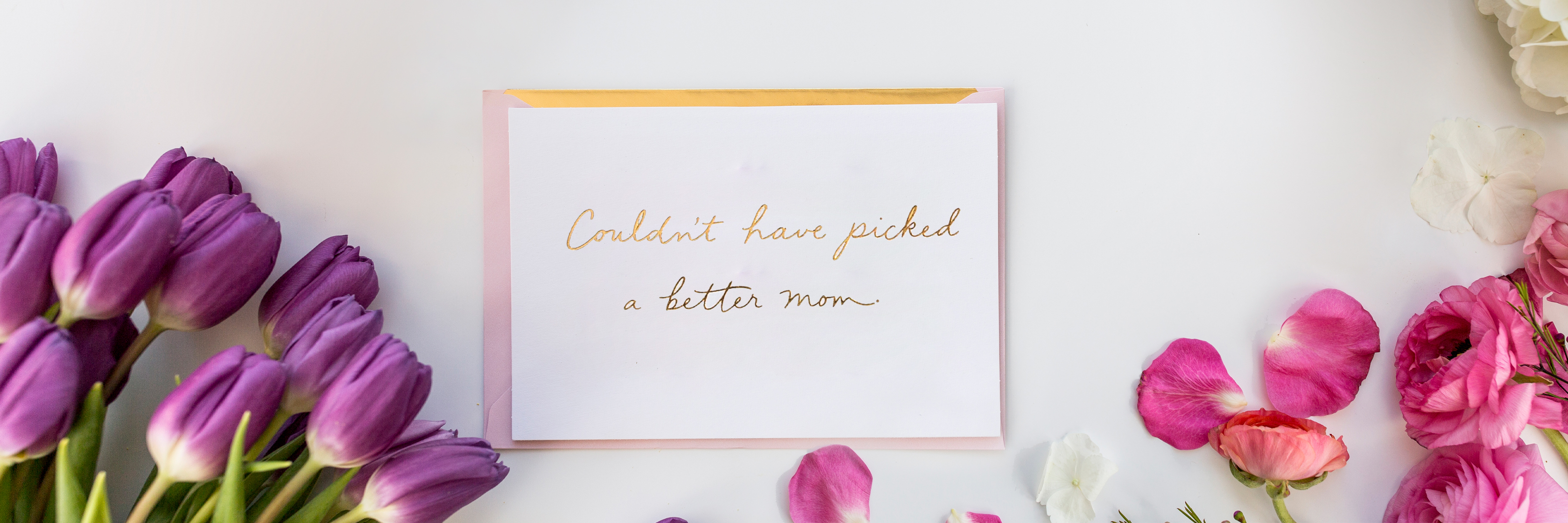 A heartfelt card surrounded by vibrant tulips and colorful flower petals, celebrating love.