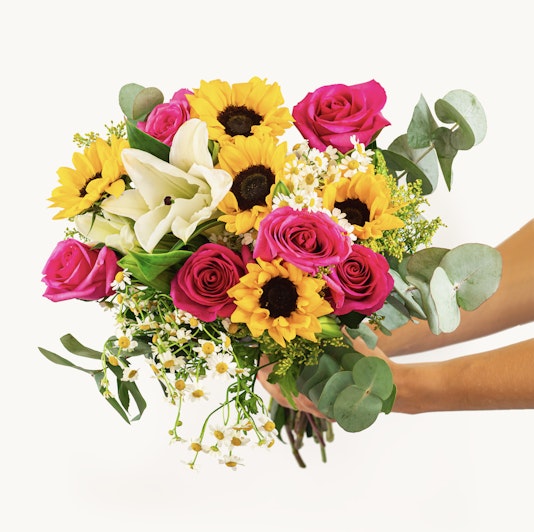 Vibrant bouquet featuring sunflowers, pink roses, and white lilies, perfect for celebrations.
