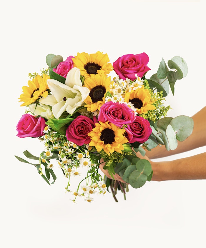 Vibrant bouquet featuring sunflowers, pink roses, and white lilies, perfect for celebrations.